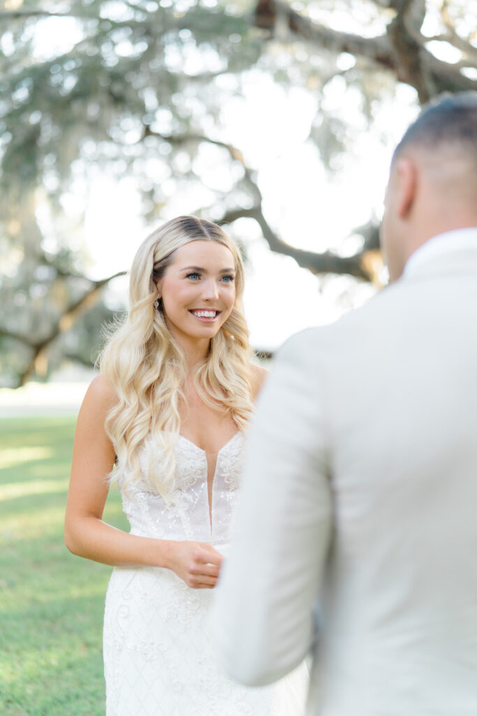 Bride with blond hair and bright blue eyes during vow reading with groom. Charleston photographer wedding