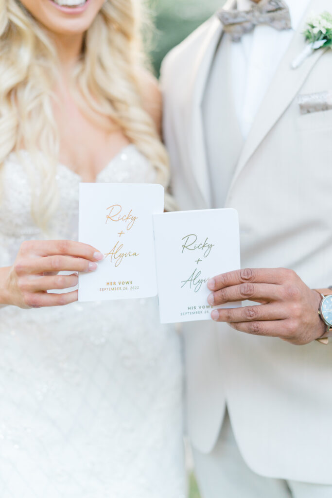 Bride and groom holding custom white vow books. photographers in charleston. 