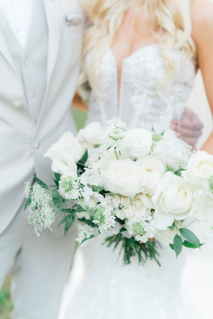 Close up of bride and groom with bride holding white and green bouquet. charleston sc wedding photography.