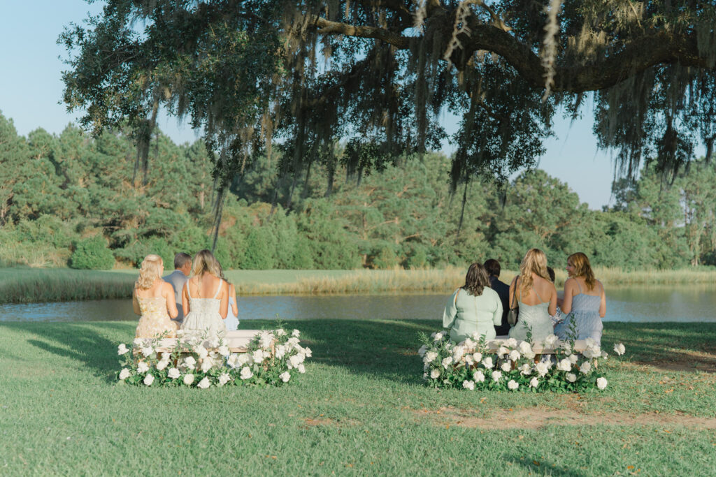 Intimate wedding ceremony under a live oak tree with spanish moss. Soft pastel tones. Charleston destination wedding.