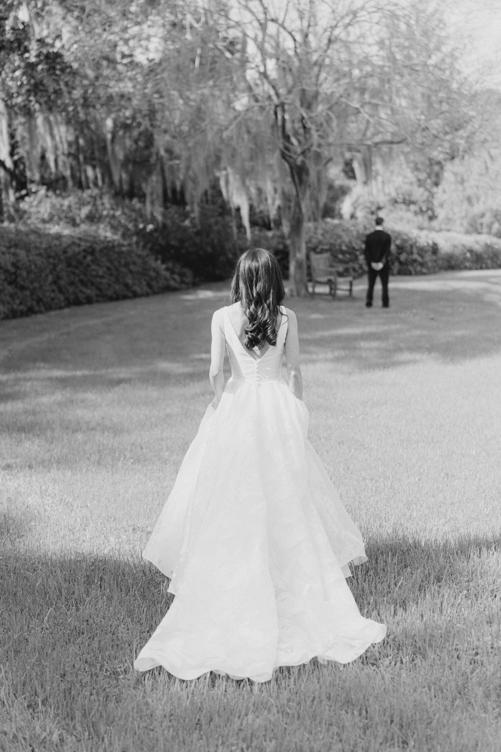 Bride walks up to groom in the garden during first look. 