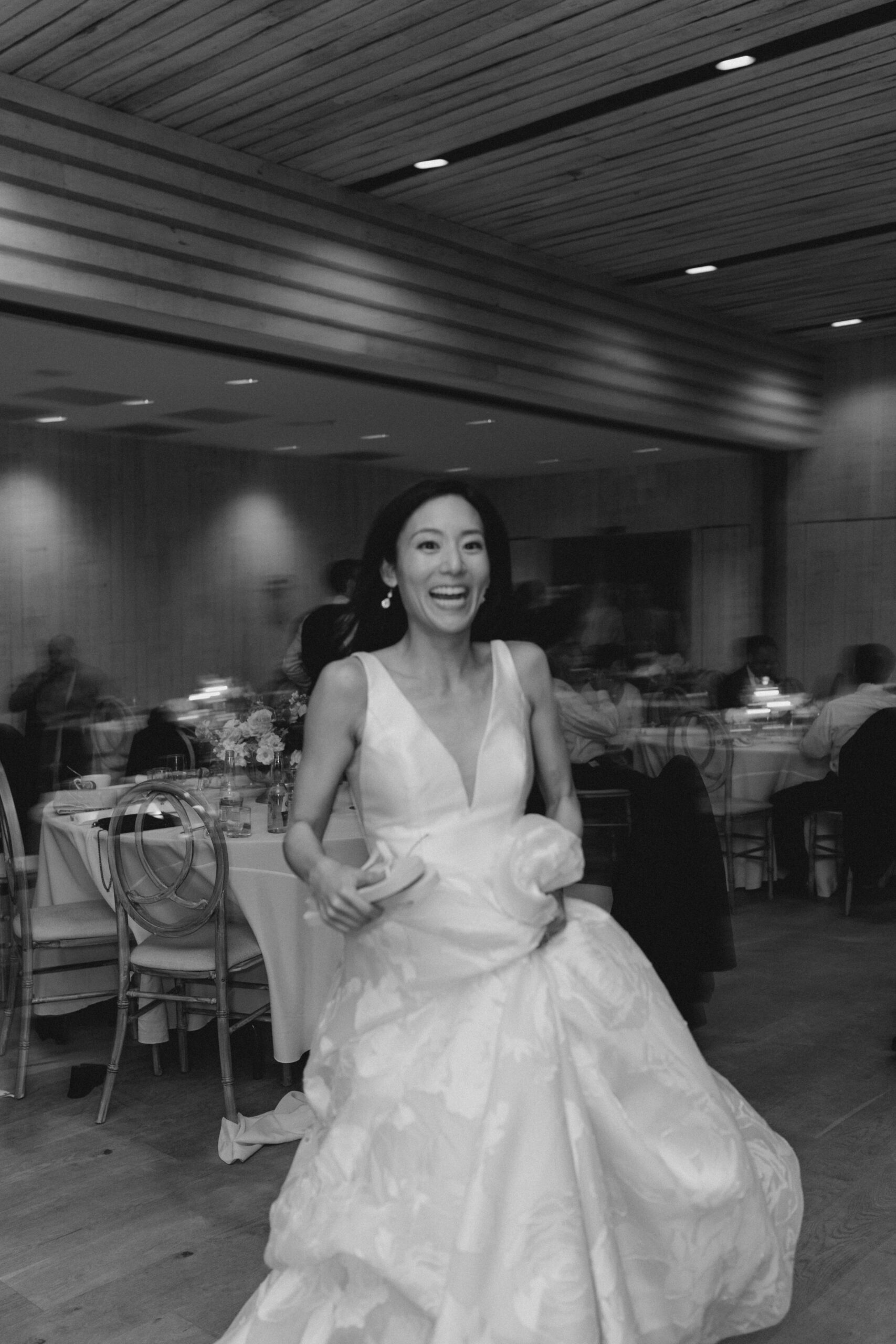 Blurry black and white photo of bride going to get flip flops for wedding reception. 