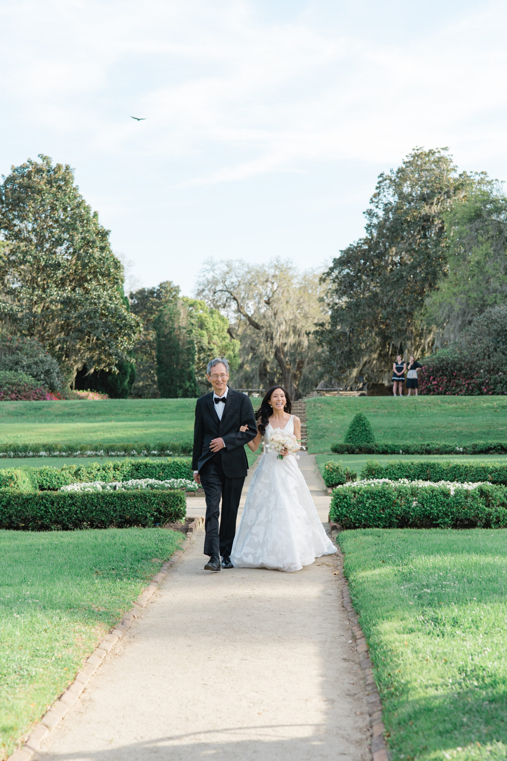 Father of the bride escorts his daughter up the aisle during wedding ceremony at Middleton Place. 