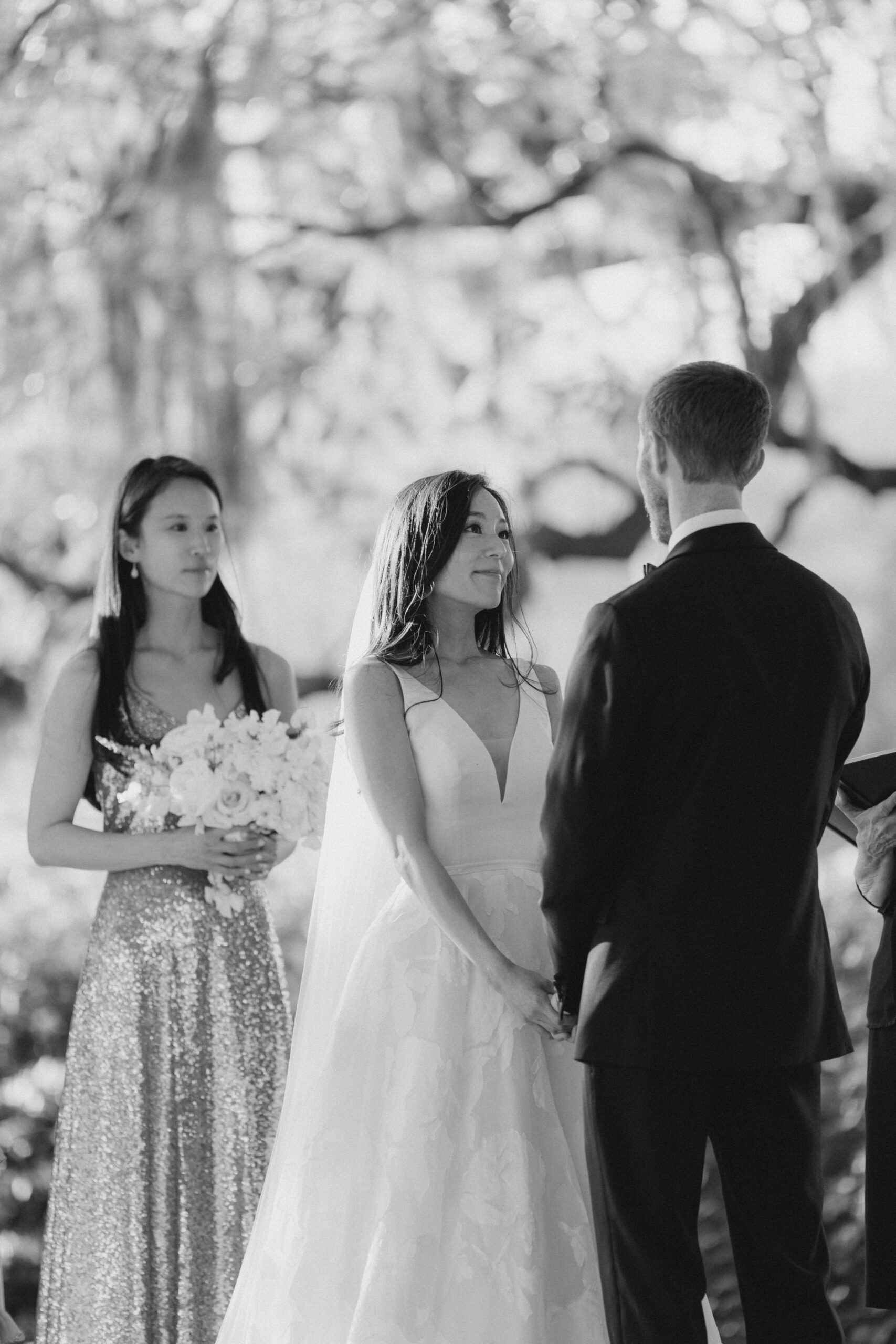 black and white photo of bride looking lovingly at groom during outdoor wedding ceremony. Destination wedding photographer. Kailee DiMeglio Photography.