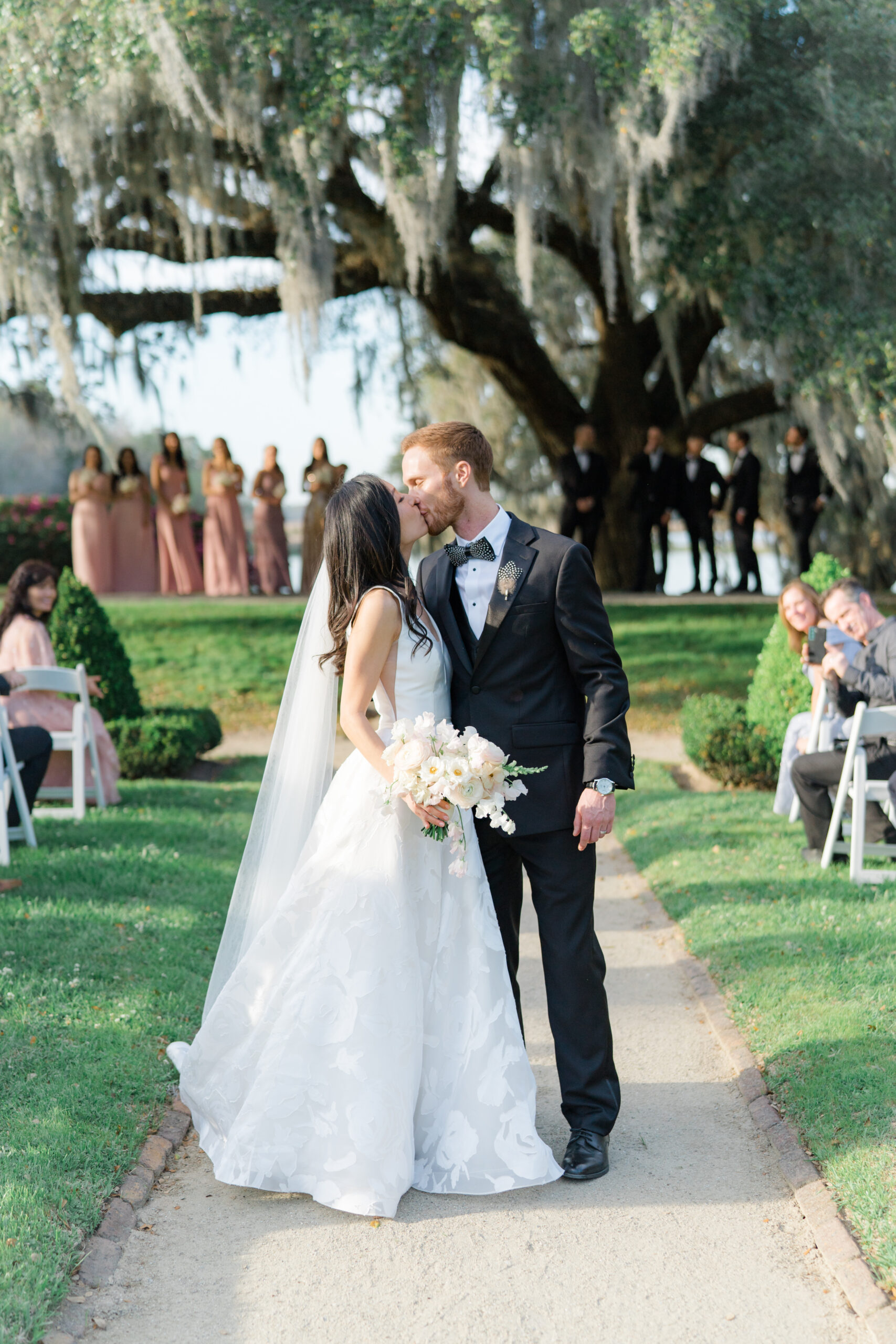 Middleton Place wedding ceremony aisle exit kiss. Perfect lighting. Red-head groom and asian bride. Charleston destination wedding.