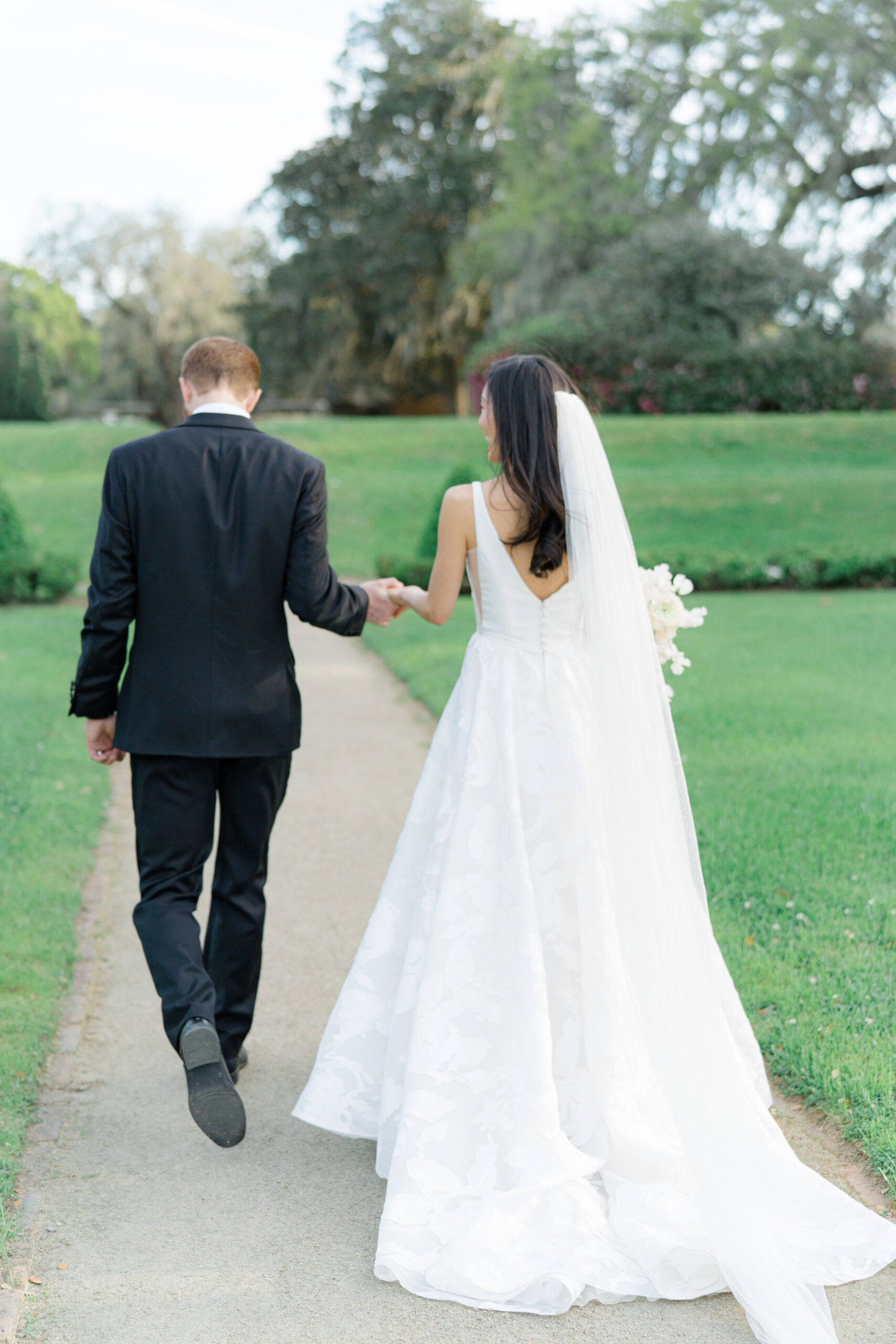 Bride and groom walking away from wedding ceremony in octagonal garden. 