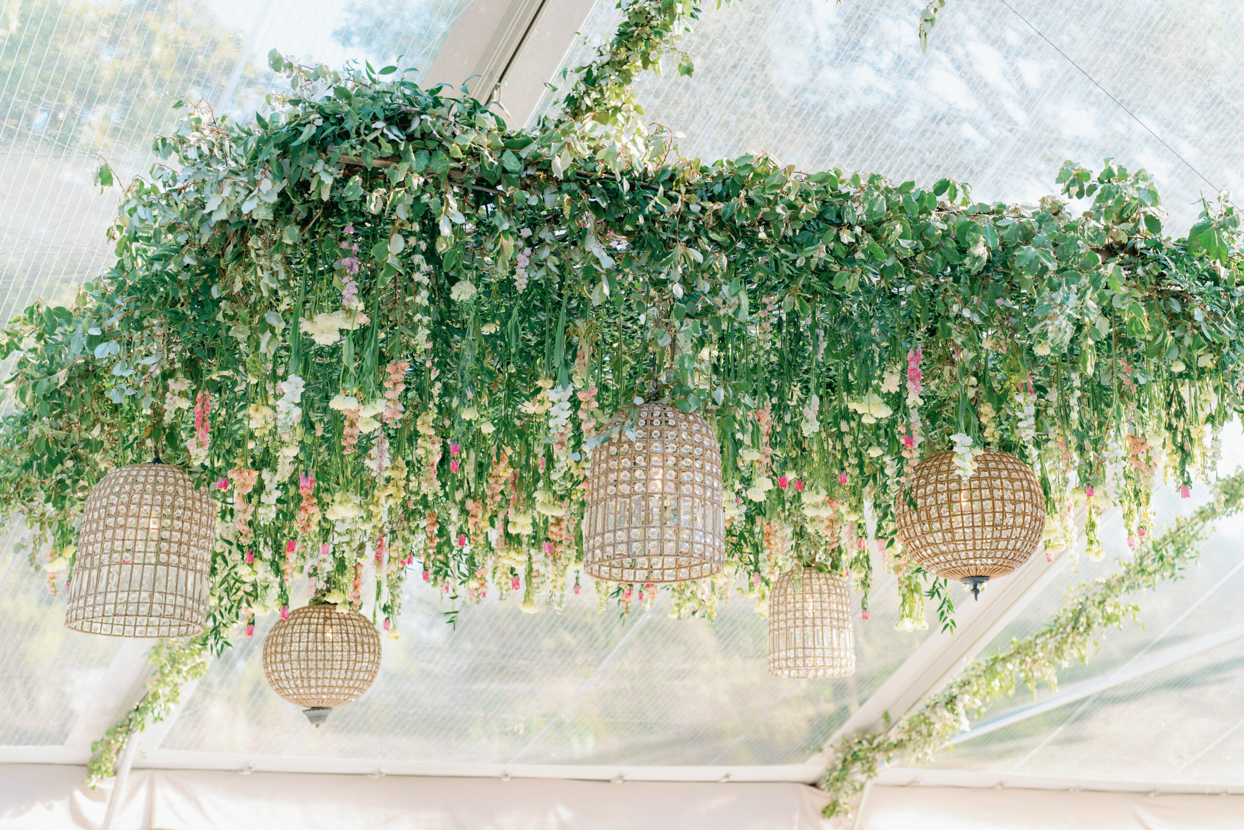 Hanging flower installation with white, pink, and yellow flowers.
