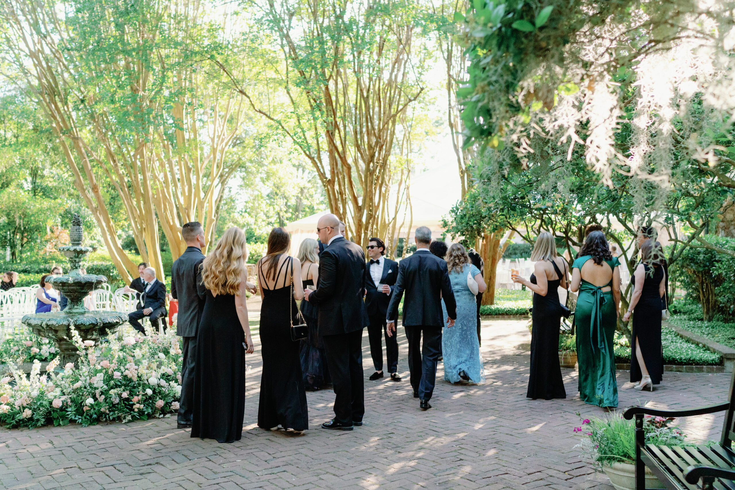 Cocktail hour in the courtyard. Downtown Charleston wedding reception with lush greenery.