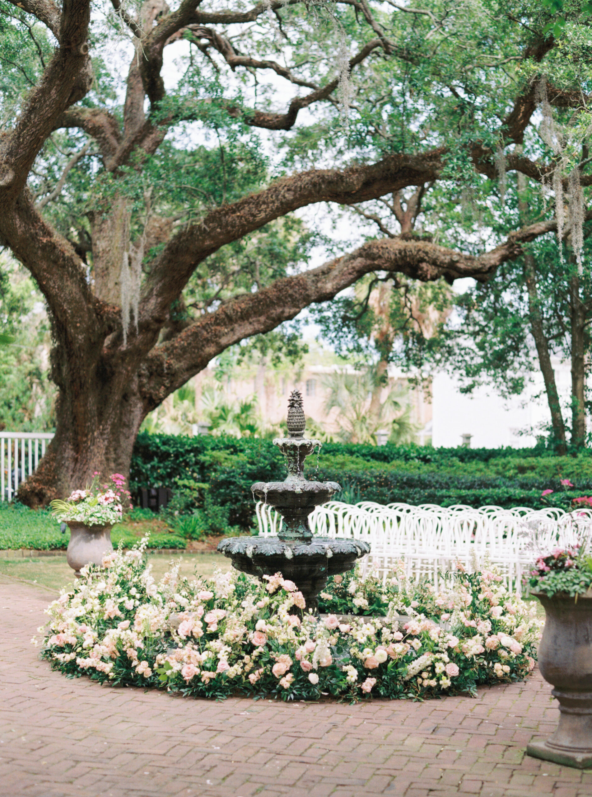 Film photo of thomas bennett house fountain decorated in white and pink flowers. 