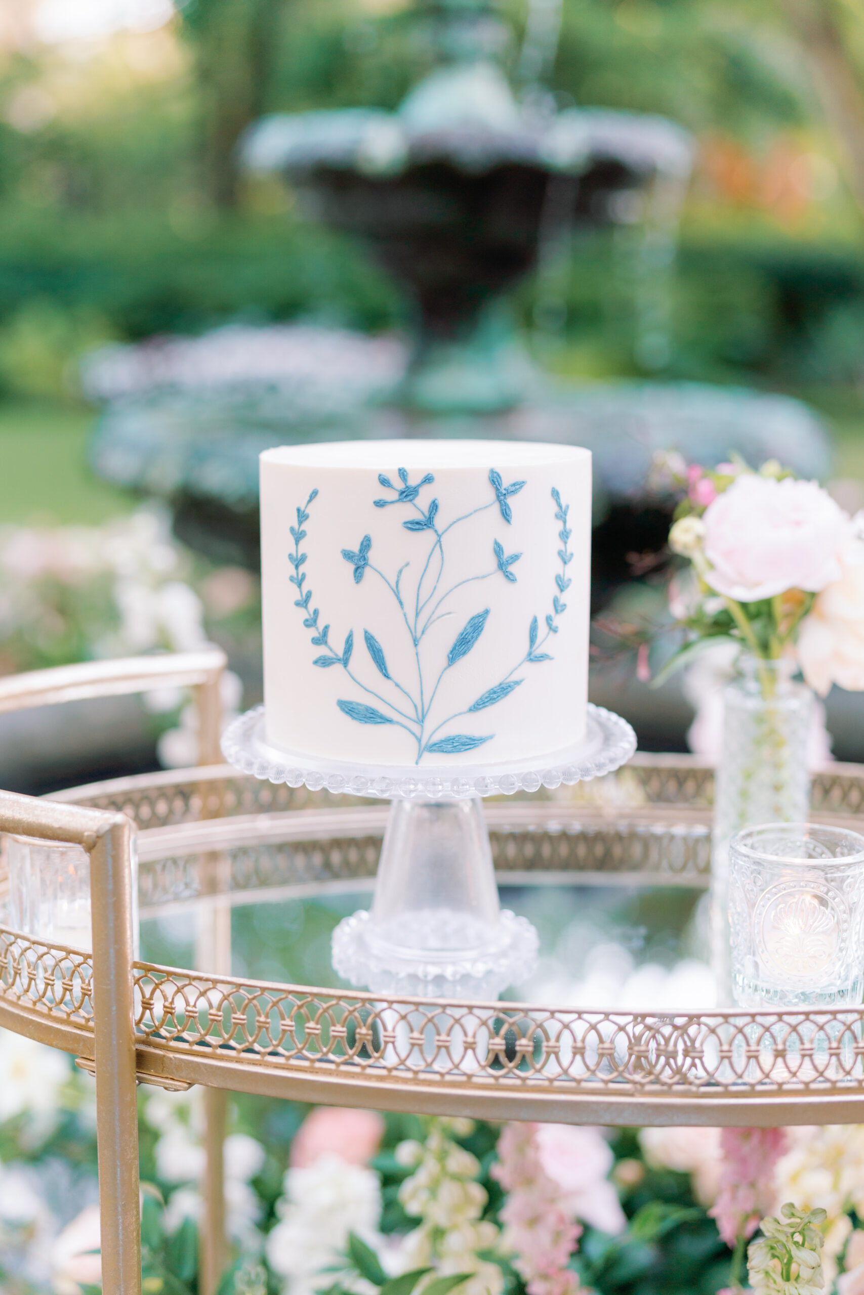 Simple white wedding cake with blue wildflower detail.