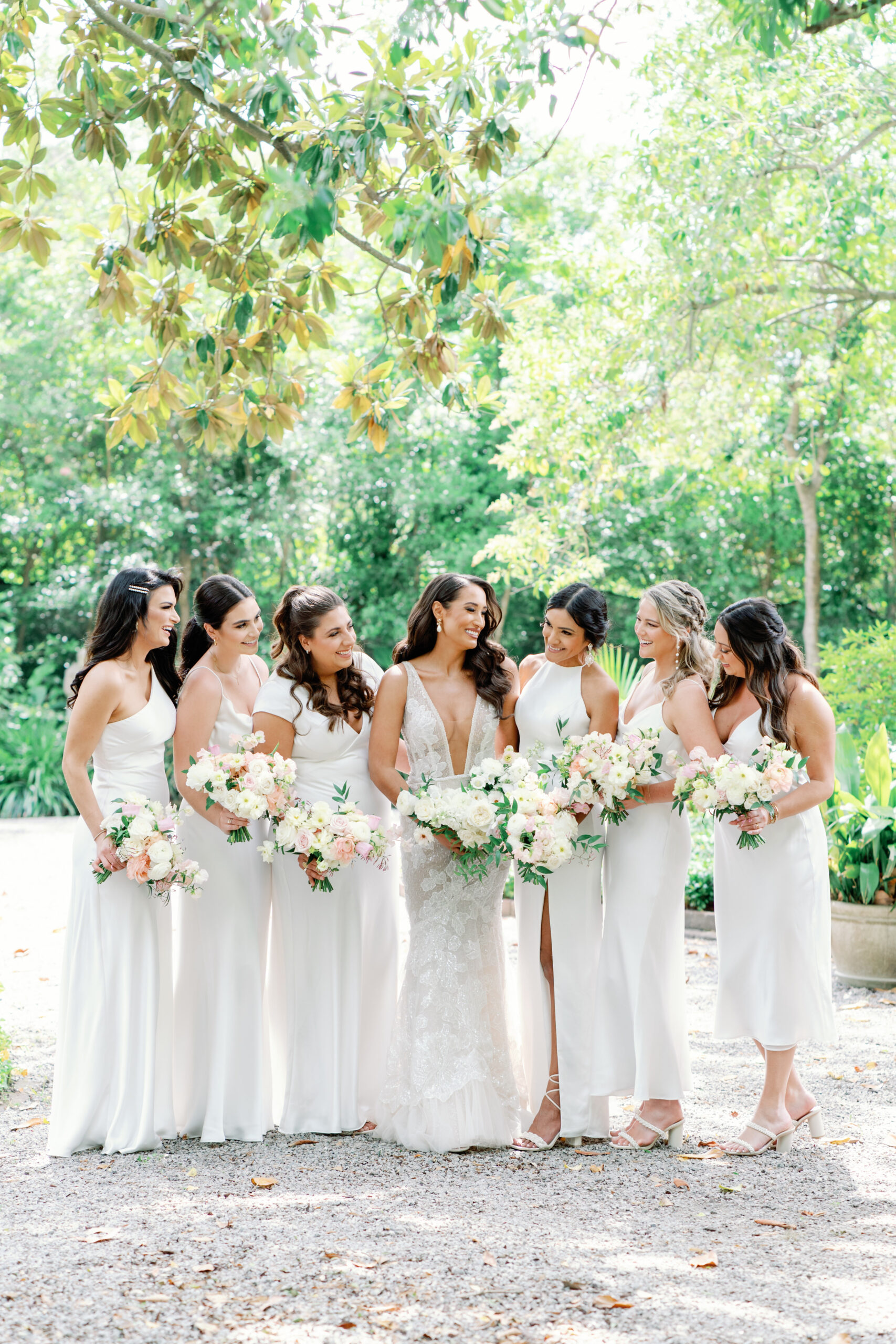 Bridesmaids in all white dresses with different cuts. Spring wedding