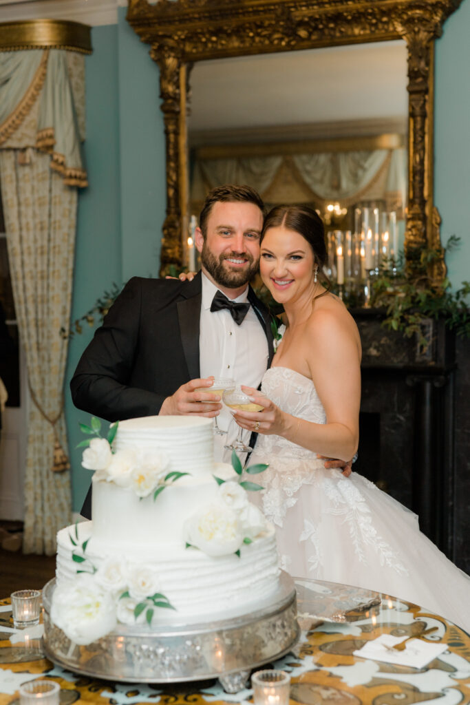 Bride and groom champagne toast after cutting wedding cake at Charleston wedding.