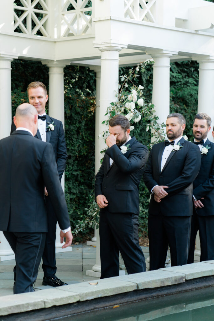 Groom wipes away tears when he first sees the bride during William Aiken House wedding ceremony.