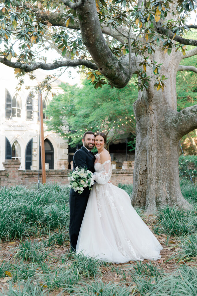 Bride and groom portrait under the magnolia tree at William Aiken House. 