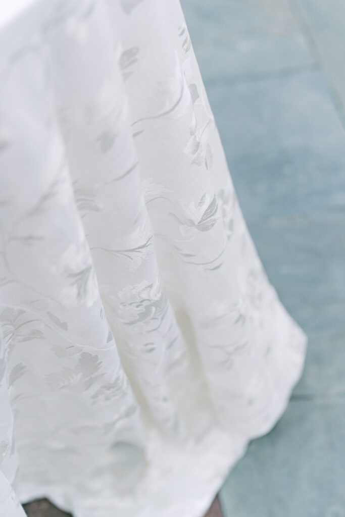 White wedding table linens with flower embellishment. 