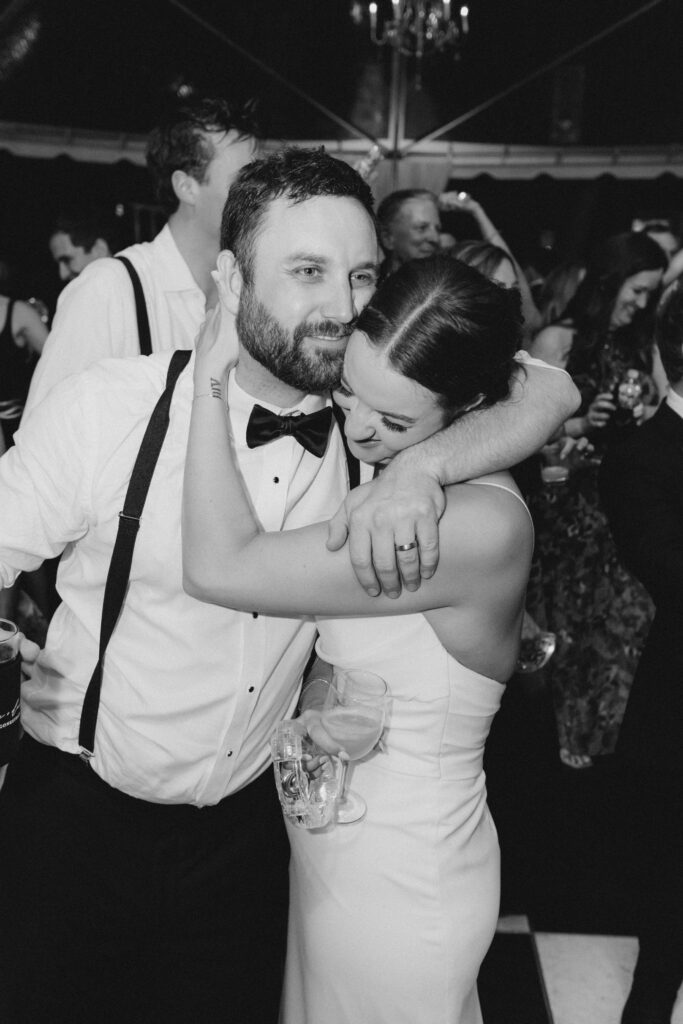 Black and white photo of sweet hug between bride and groom on their wedding night. 