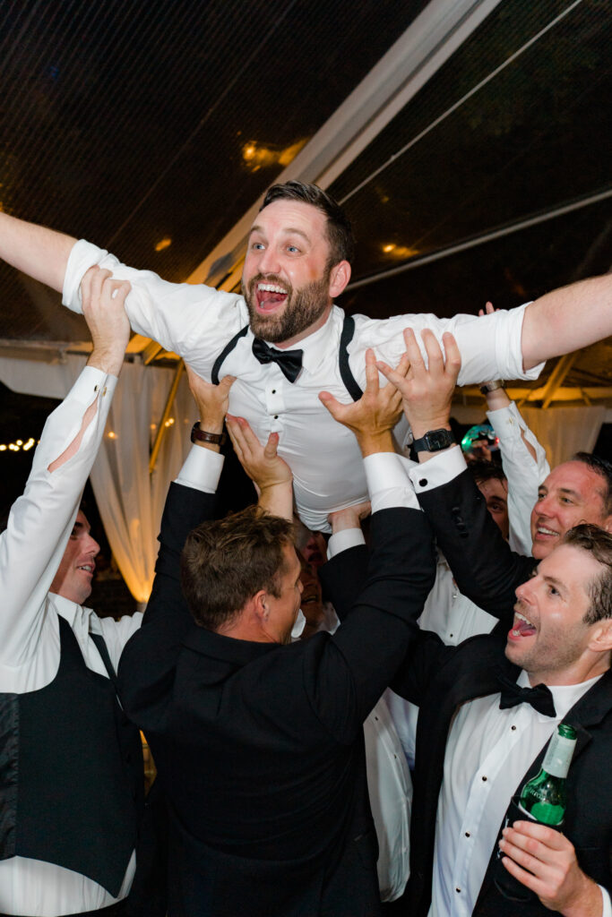 Groom crowd surfs at his wedding reception. wedding photographers in charleston sc. 