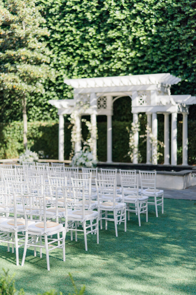 Charleston wedding ceremony with white chiavari chairs, white cushions, and reed fans on every chair. 