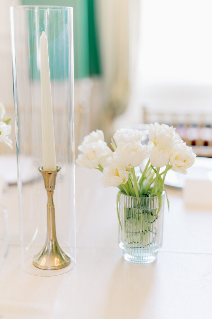 White tulips and tall white candlestick. 