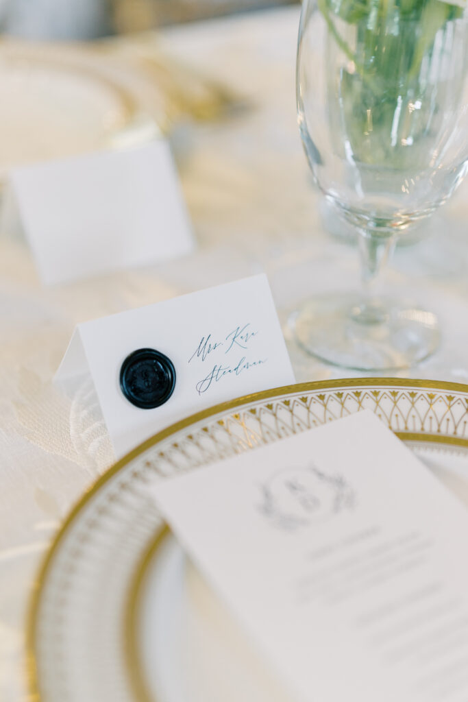 Wedding reception place setting name card. Gold and white colors.