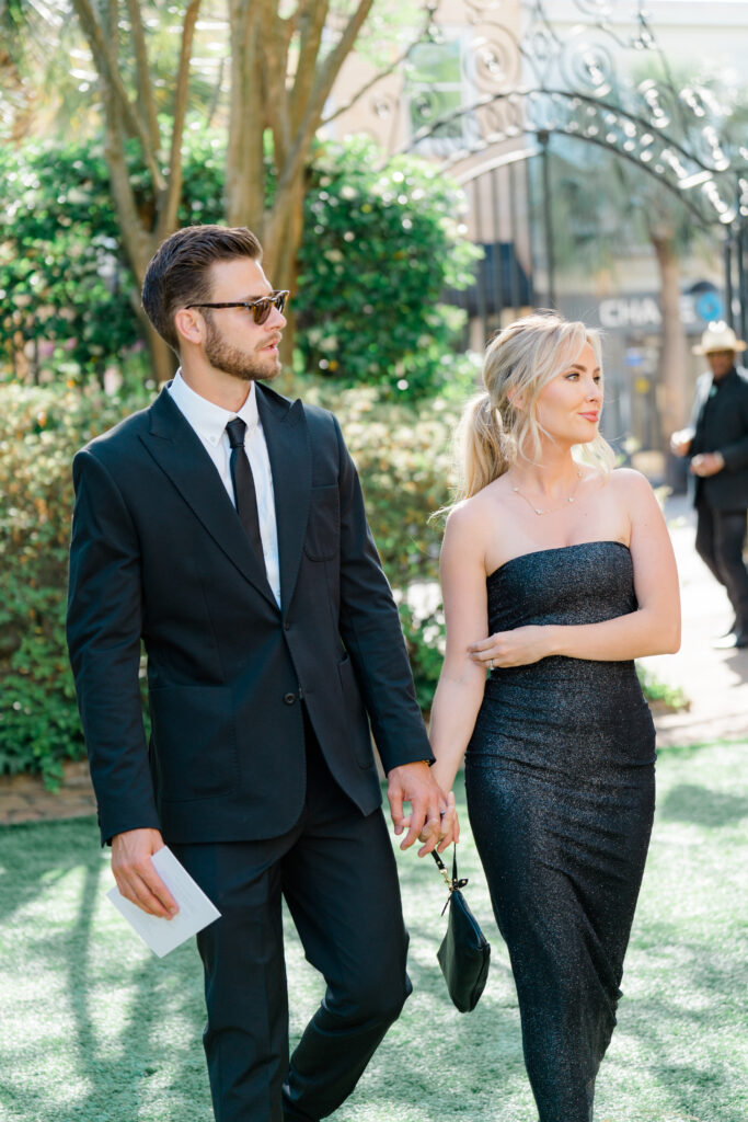 Black tie Charleston wedding guest outfits. Blonde girl in black dress. Guy in black suit with black tie. 