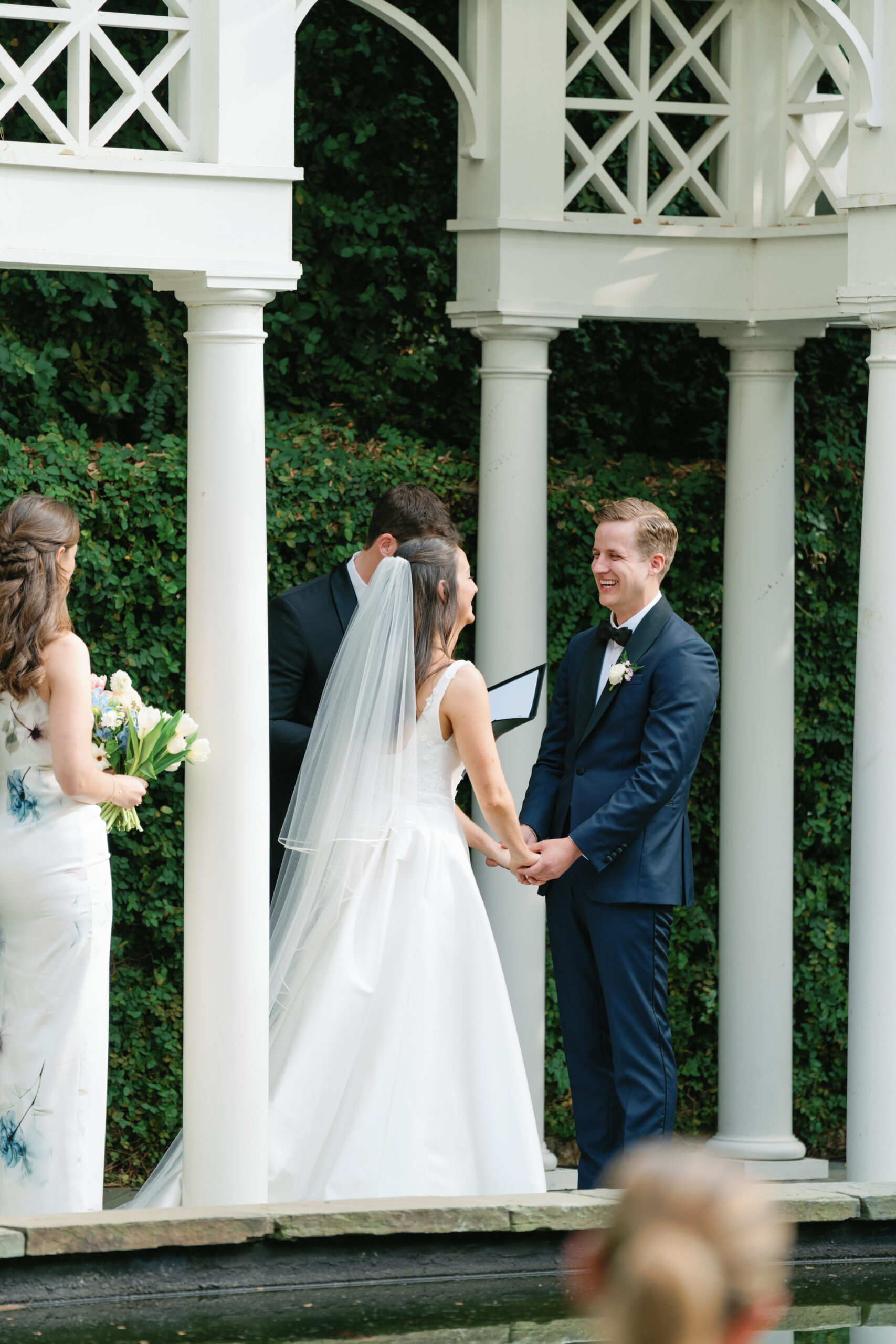 Groom laughs with bride during wedding ceremony at William Aiken House. 