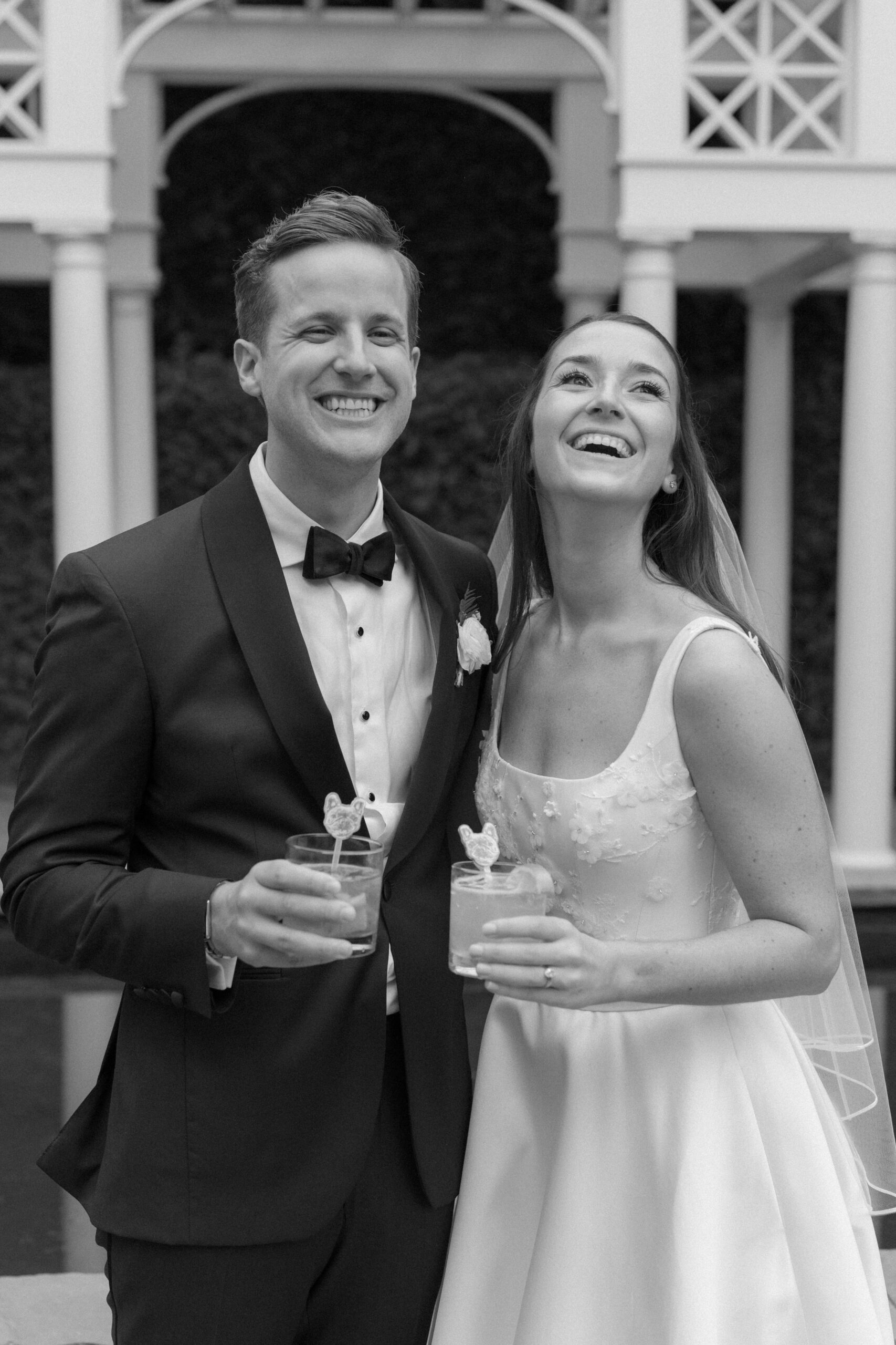 Black and white photo of the bride and groom at cocktail hour. 