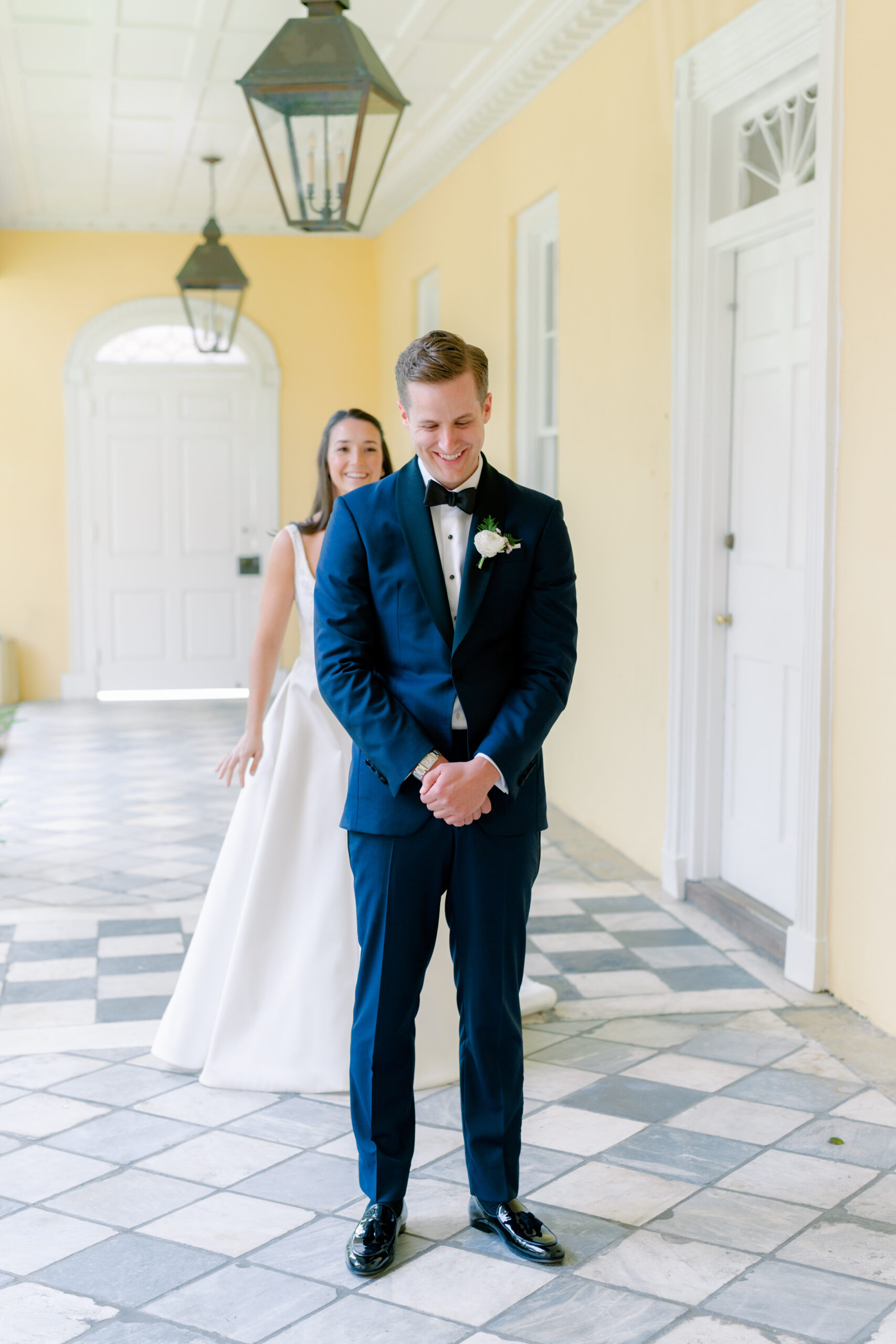 Bride and groom first look at William Aiken House. yellow walls and checkerboard floor.