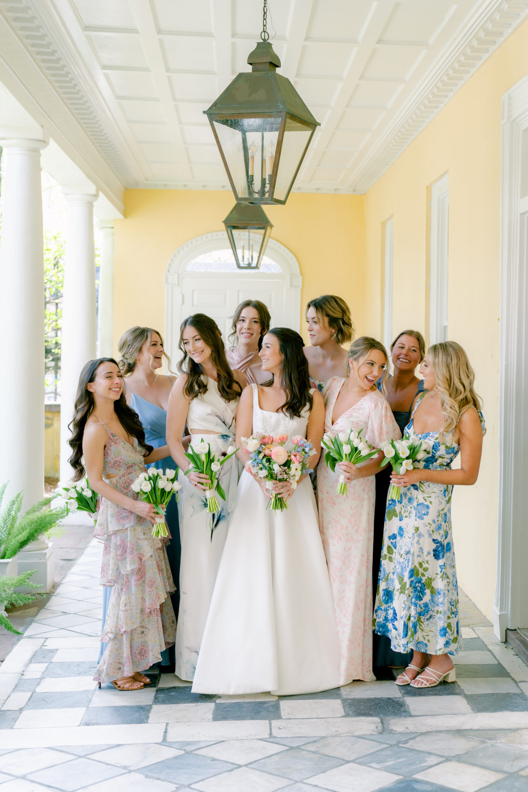 Bride and bridesmaids standing on checkerboard floor at historic Charleston home. 