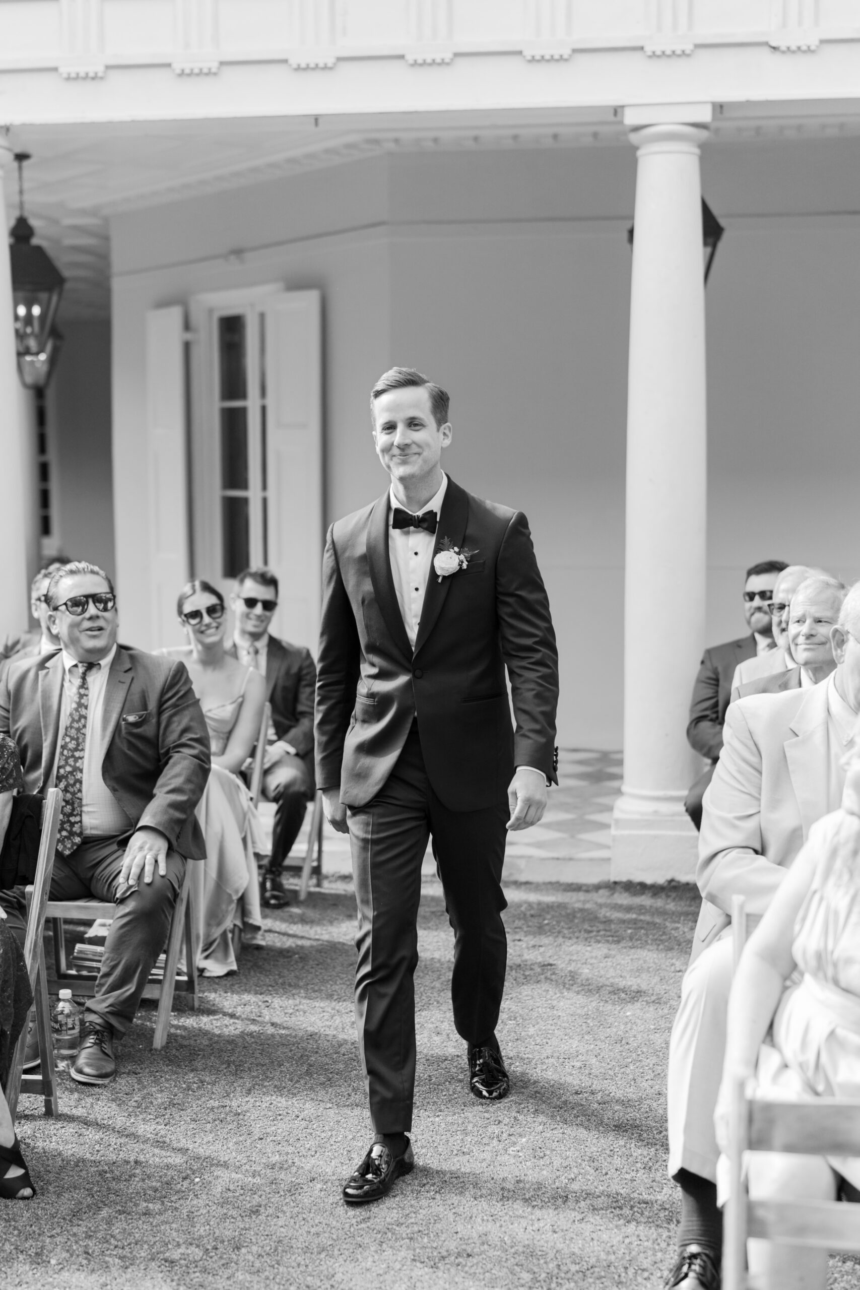 Black and white photo of groom entering wedding ceremony at William Aiken House. photographer in Charleston. 