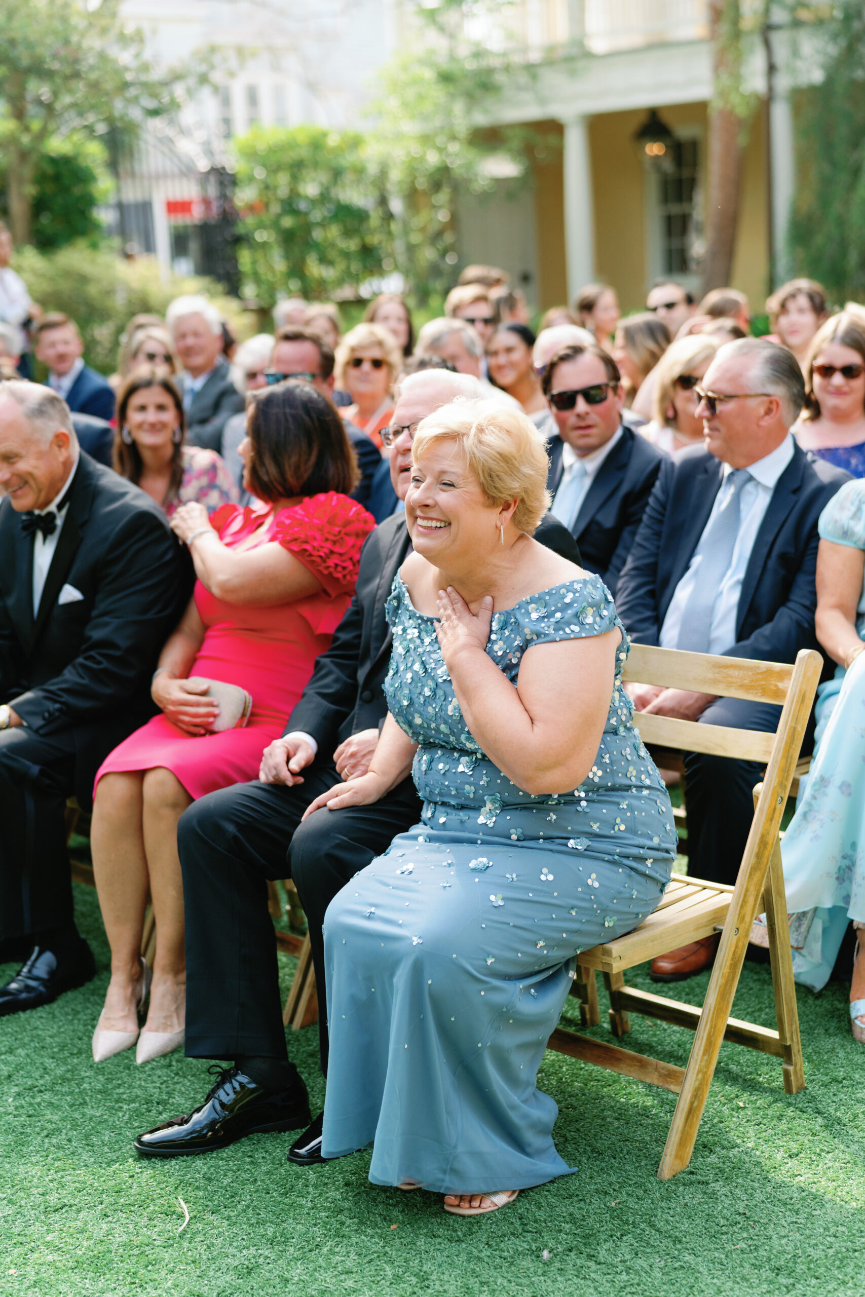 Mother of the groom smiles at her son during outdoor wedding ceremony in Charleston. 