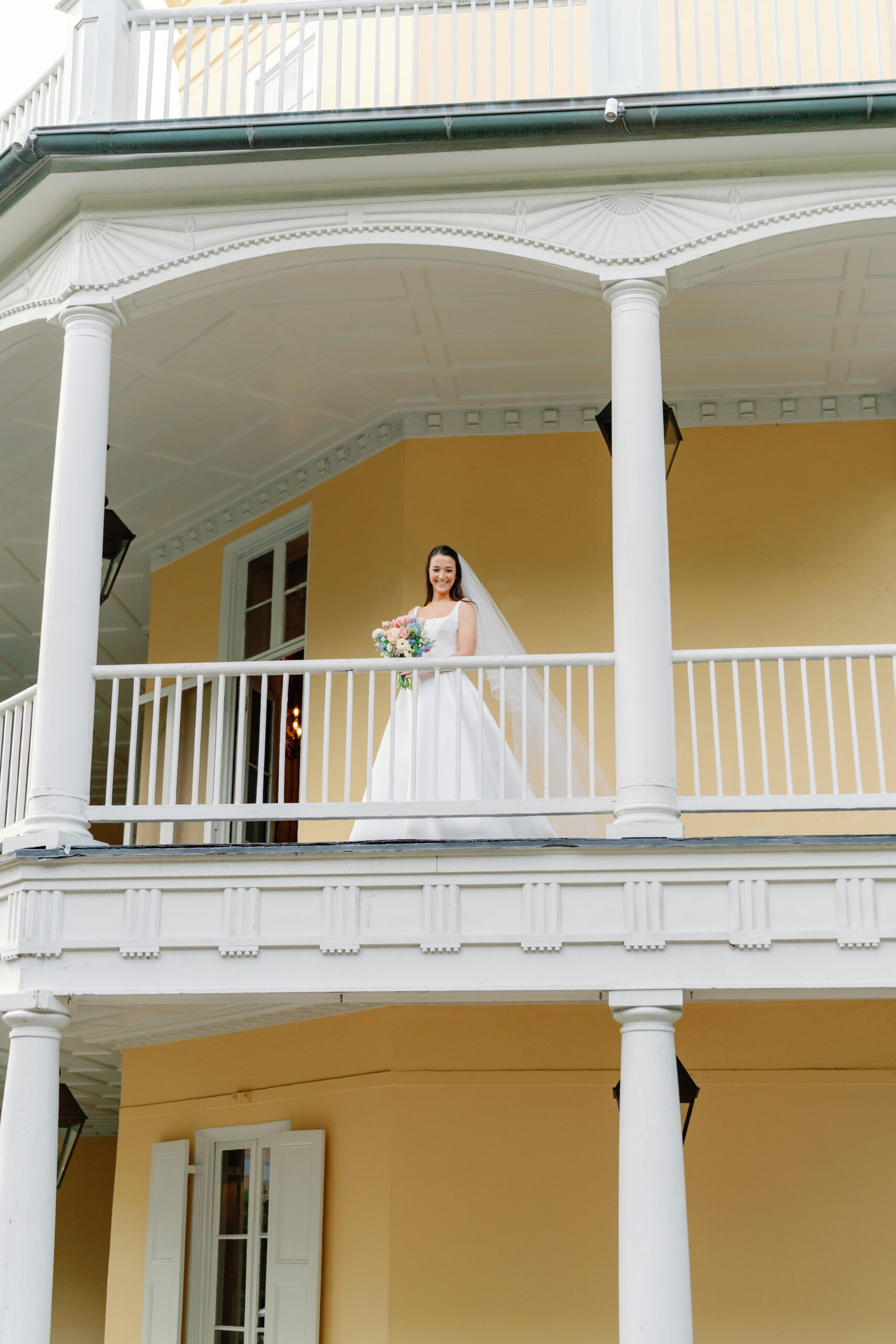 Bride walks out onto the porch before wedding ceremony at William Aiken House. 