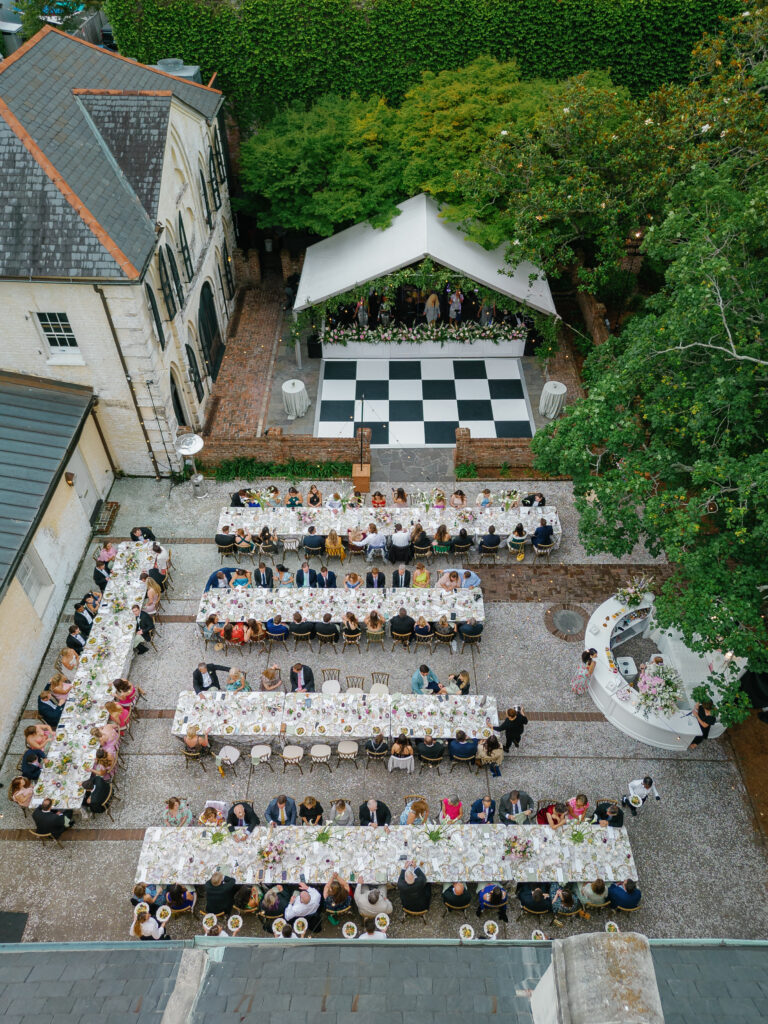 Al fresco wedding reception dinner with live band and checkerboard dance floor. 