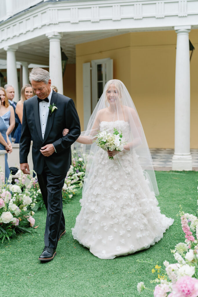 Bride walks up the aisle with her dad. 