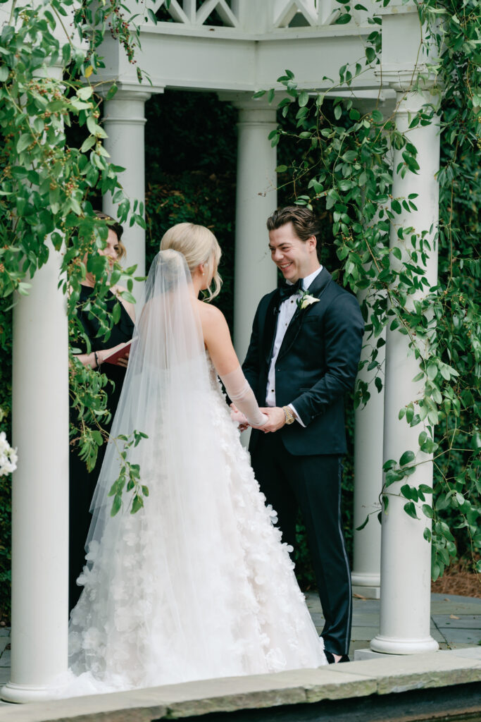 Groom laughs with bride at wedding ceremony. Charleston sc wedding photographer