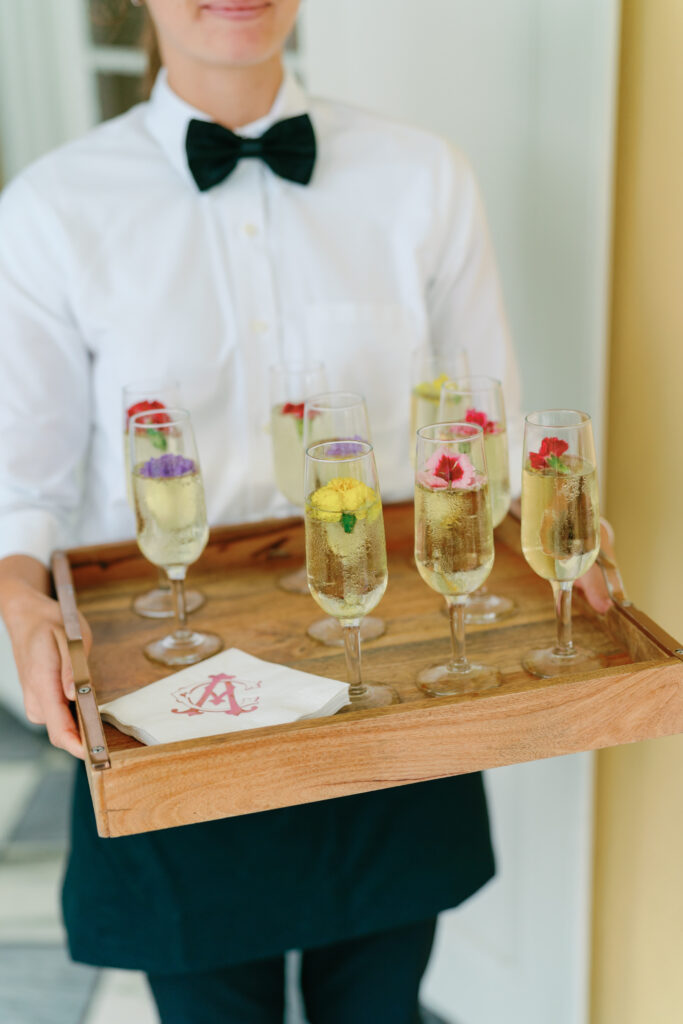 Champagne with edible flowers waiting for guests immediately following wedding ceremony. 