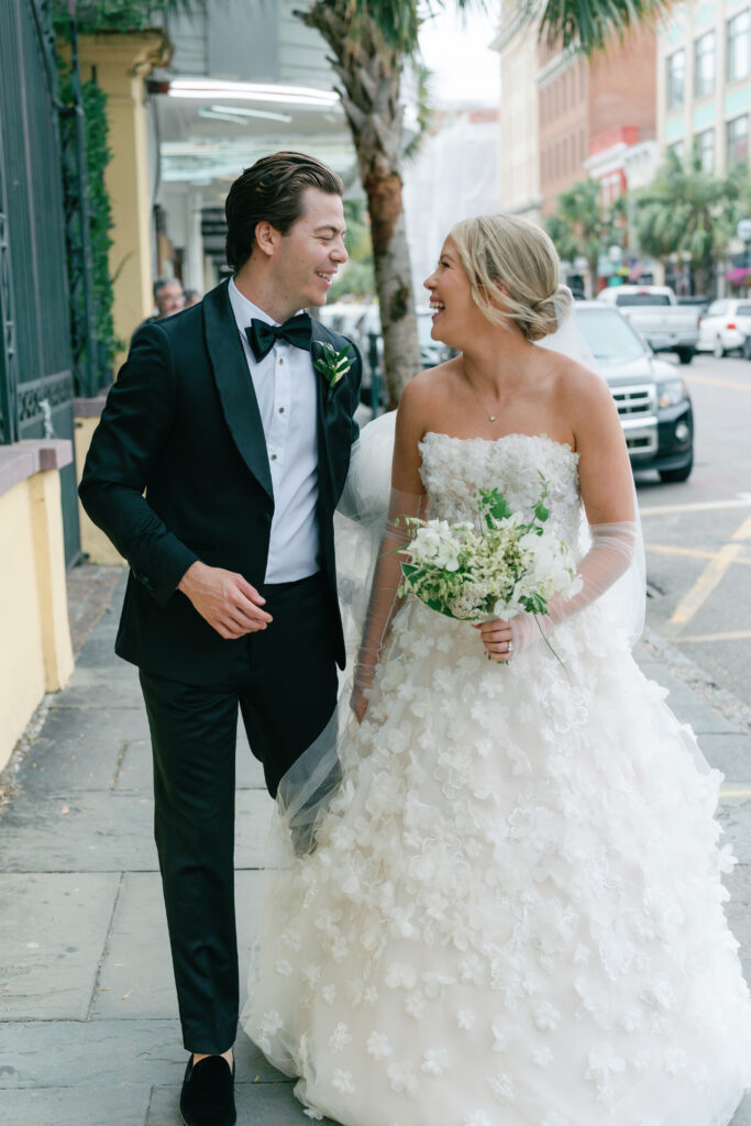 Bride and groom walking on king street in downtown Charleston.