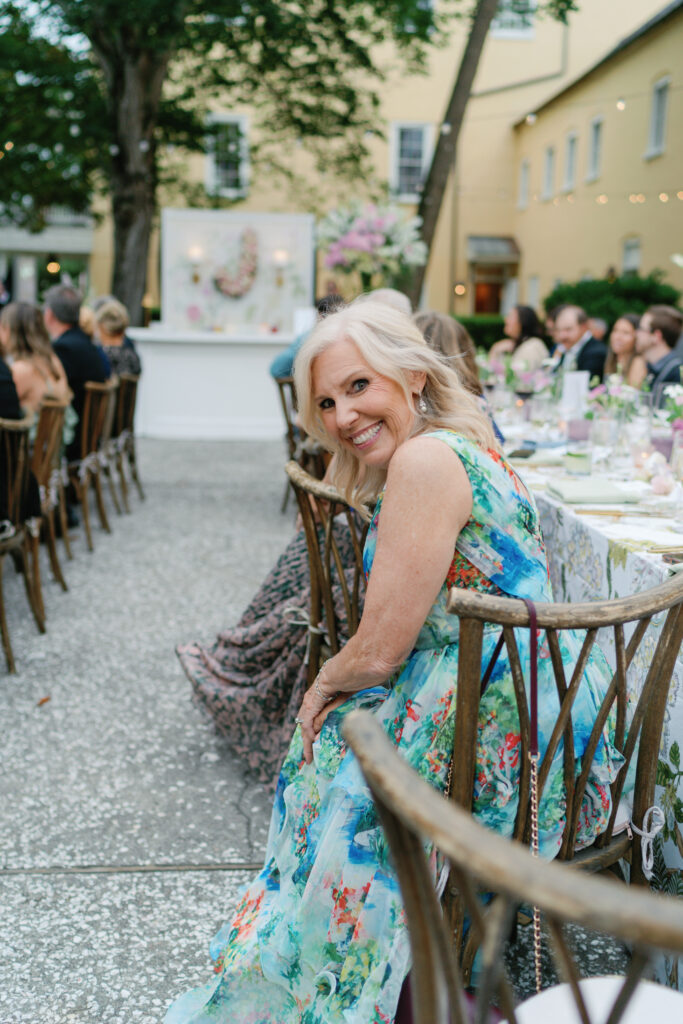 Mother of the bride smiles during wedding reception. Bold and bright mother of the bride dress.