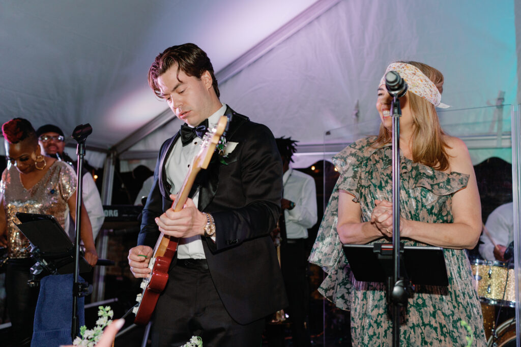 Groom sings song with mom instead of first dance. Groom playing guitar and mother singing lead vocals at wedding reception. 