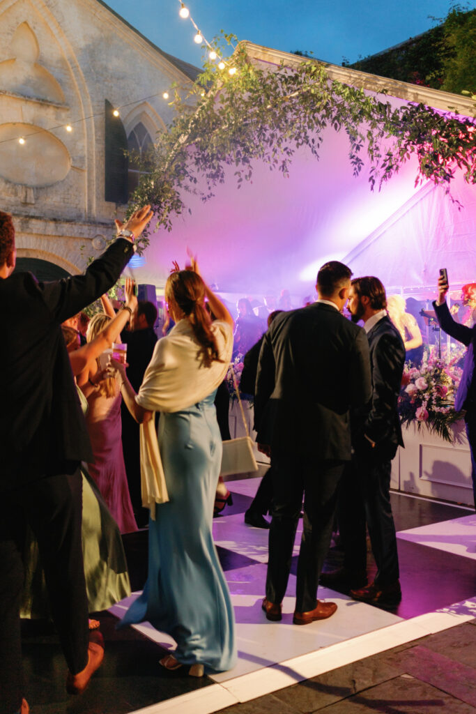 Slow shutter low light photo of wedding guests dancing with live band. 