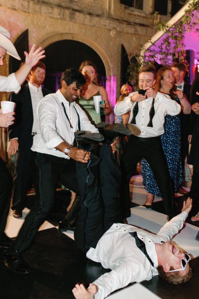 Groomsmen let loose on the dance floor at spring outdoor wedding reception. william aiken house. 