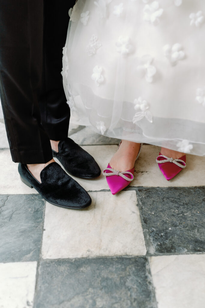 Groom's slippers and brides bright pink heels. 