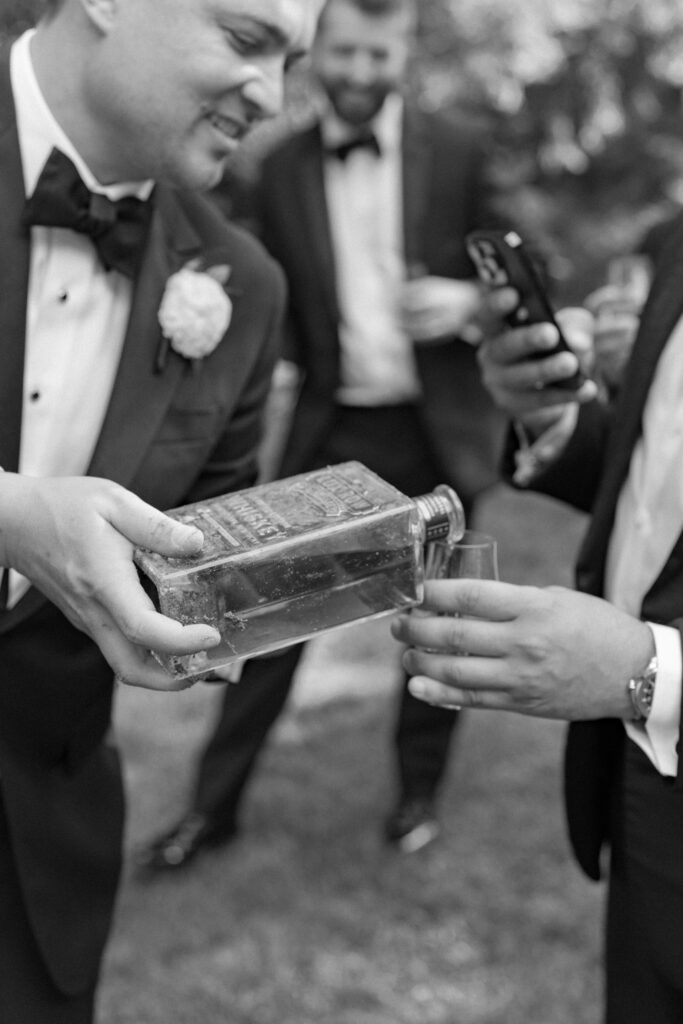 Groom pours bourbon for the bridal party. 