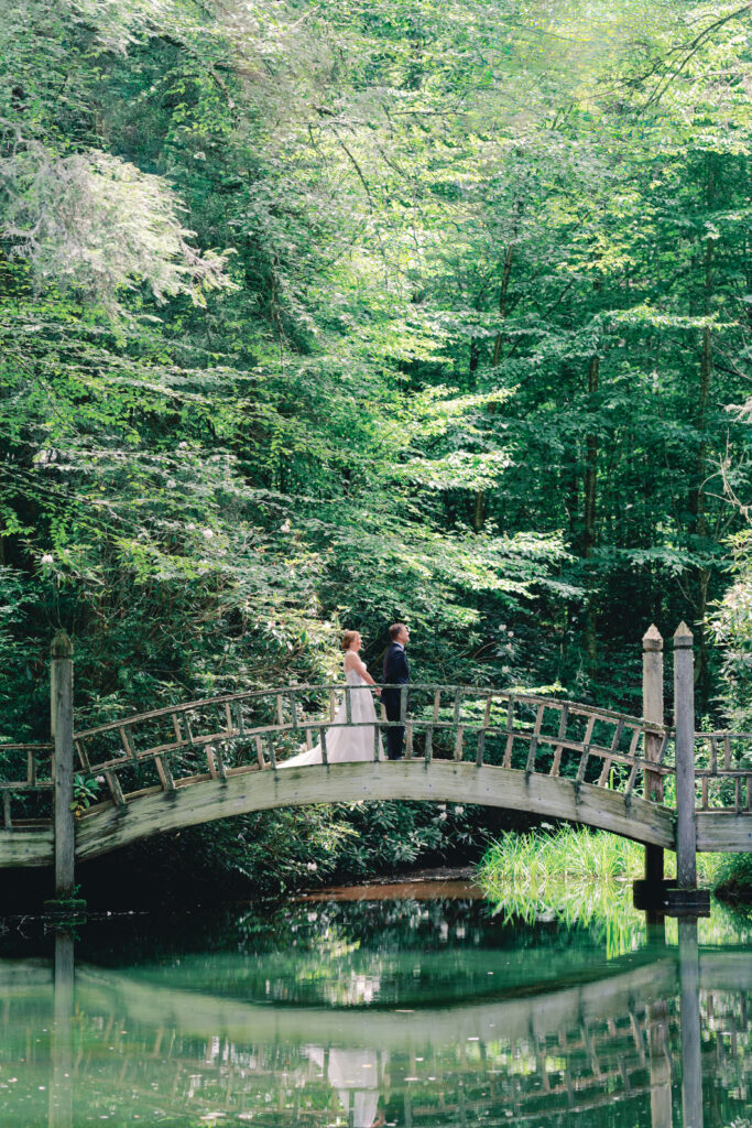 First look on the bridge over the pond at the farm at old edwards. highlands nc destination wedding.