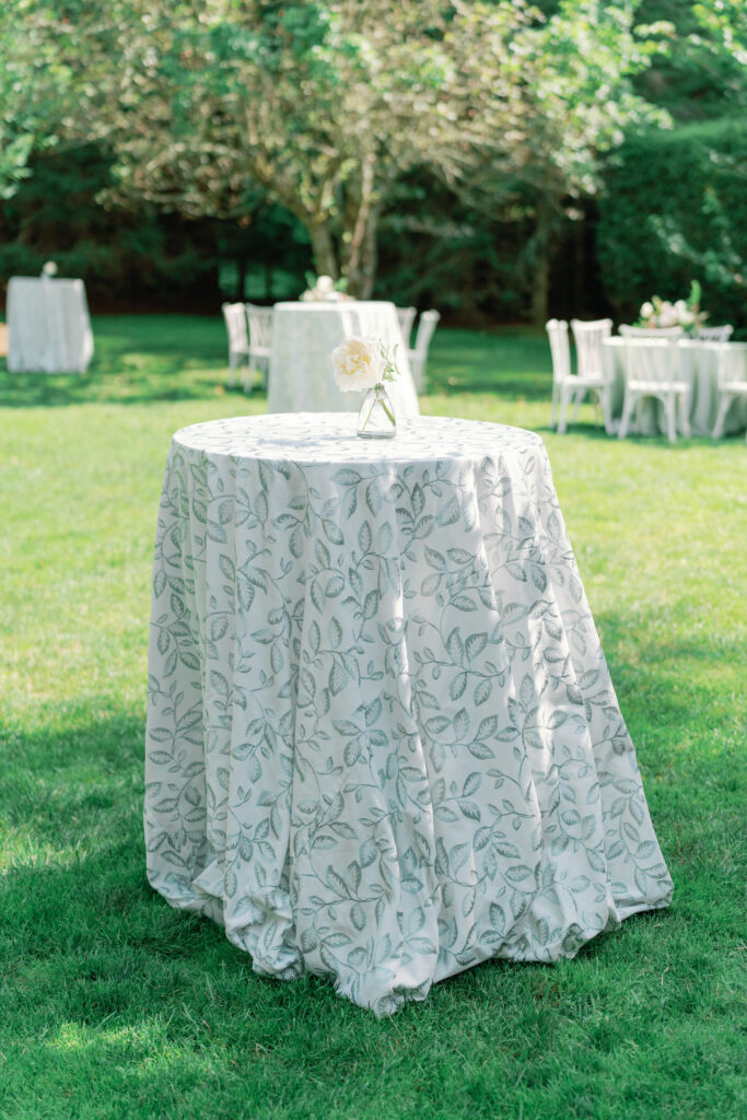 Cocktail table with white and green leaf design linens. 