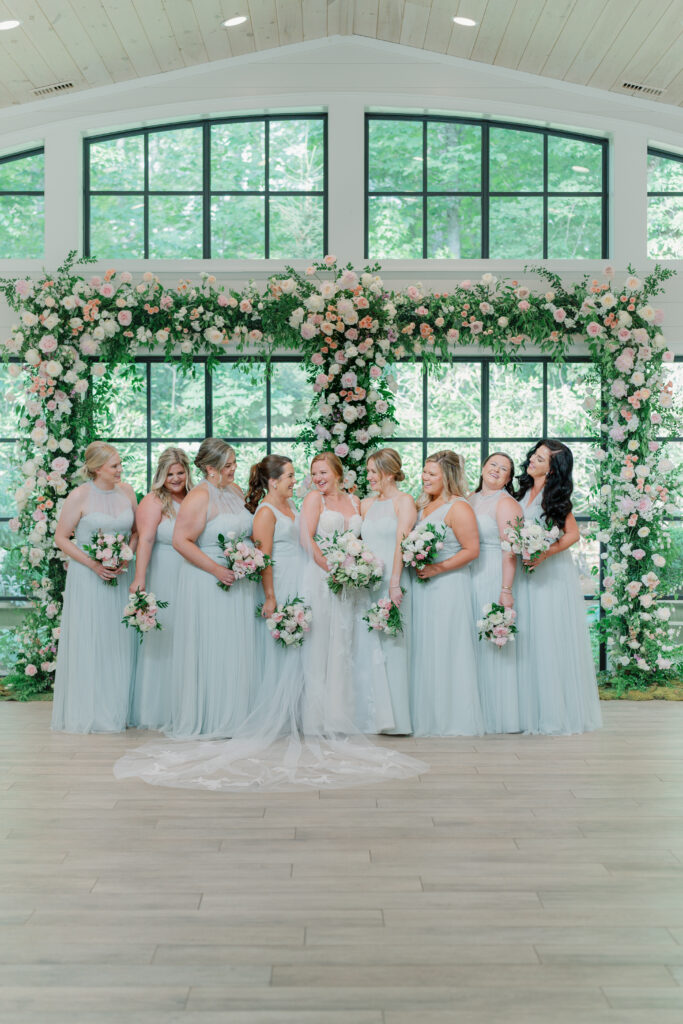 Bride and bridesmaids at the wedding ceremony florals. 