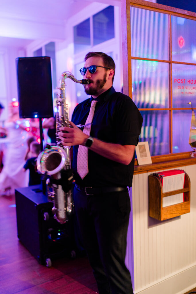 Live saxophone player with DJ at wedding reception. 
