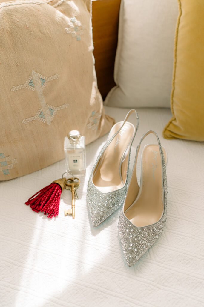 Sparkly Betsey Johnson heels, bride's perfume, and Post House Inn key. 