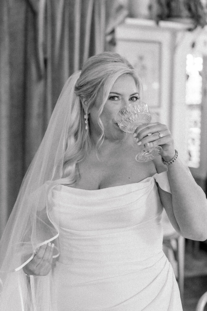 Bride sips champagne before her wedding ceremony. 