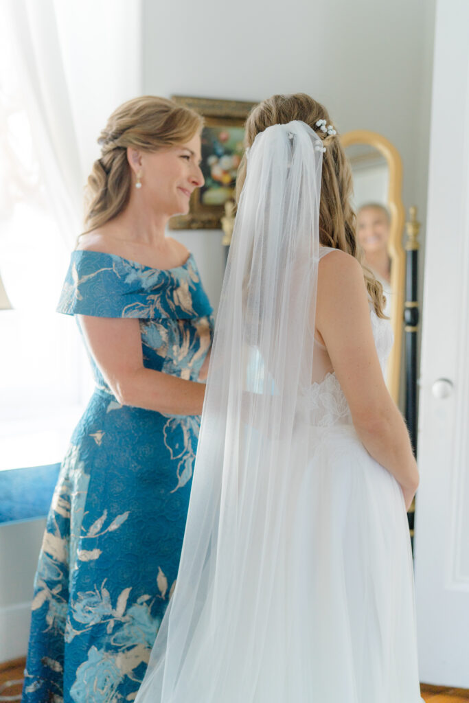 Mother of the bride in blue dress with her daughter on the morning of wedding. 